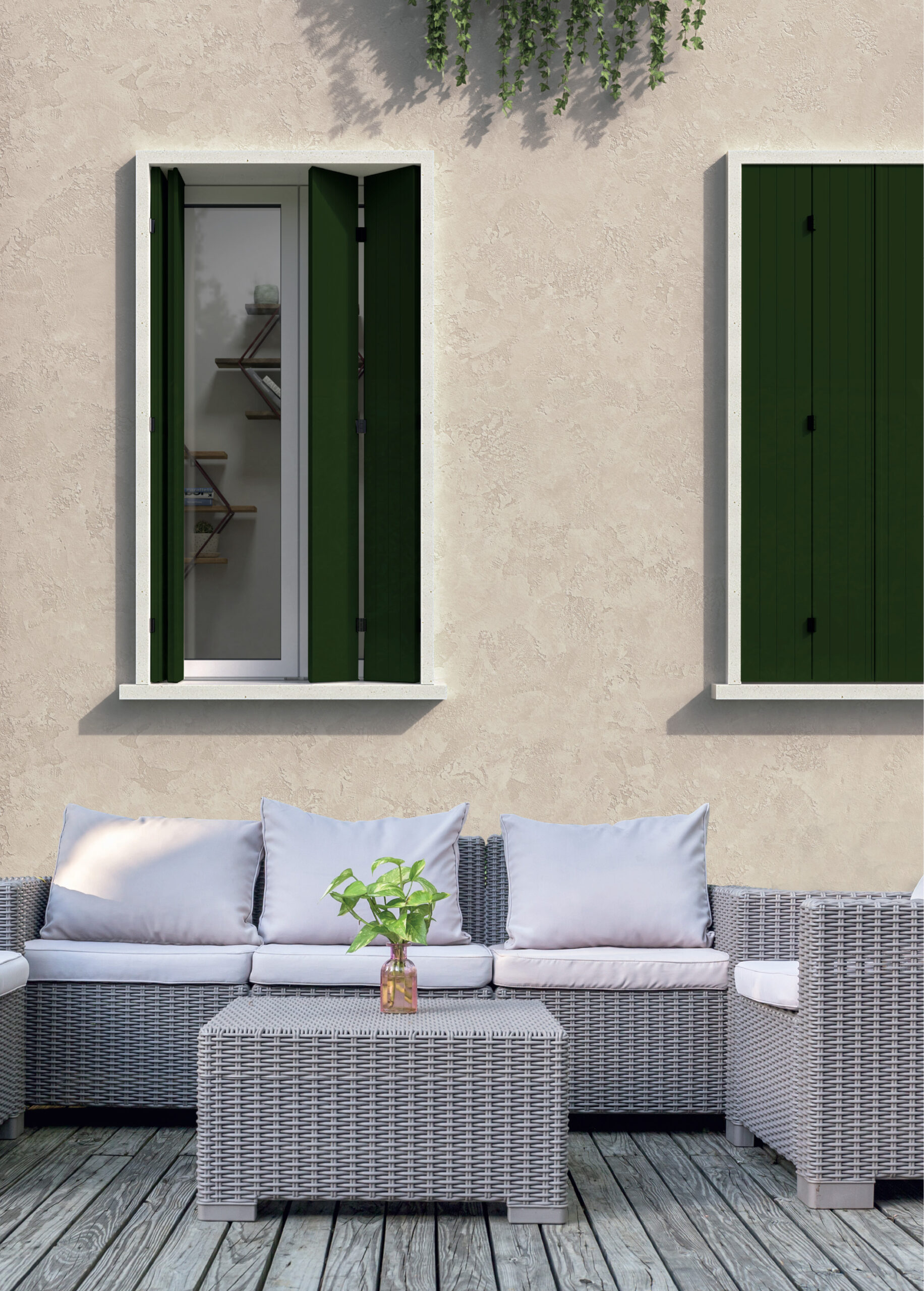 Divano esterno in rattan con cuscini bianchi e pianta decorativa su terrazzo con finestre verdi aperte, ideale per relax in spazi esterni moderni