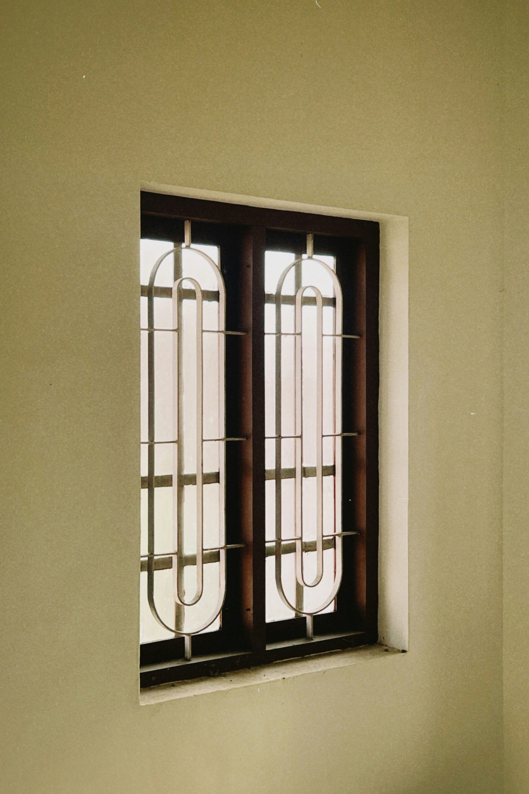 Finestra con inferriata decorativa a due ante, stile classico-elegante, tipica architettura italiana