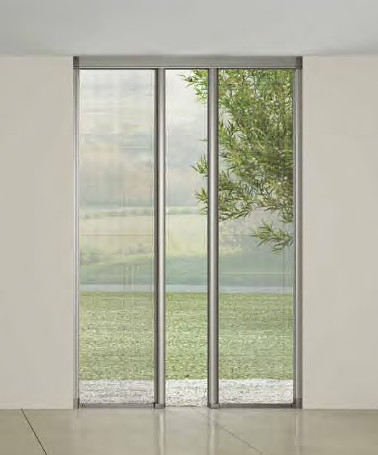 Porte scorrevoli in vetro trasparente che collegano interno ed esterno con vista su paesaggio verde e cielo